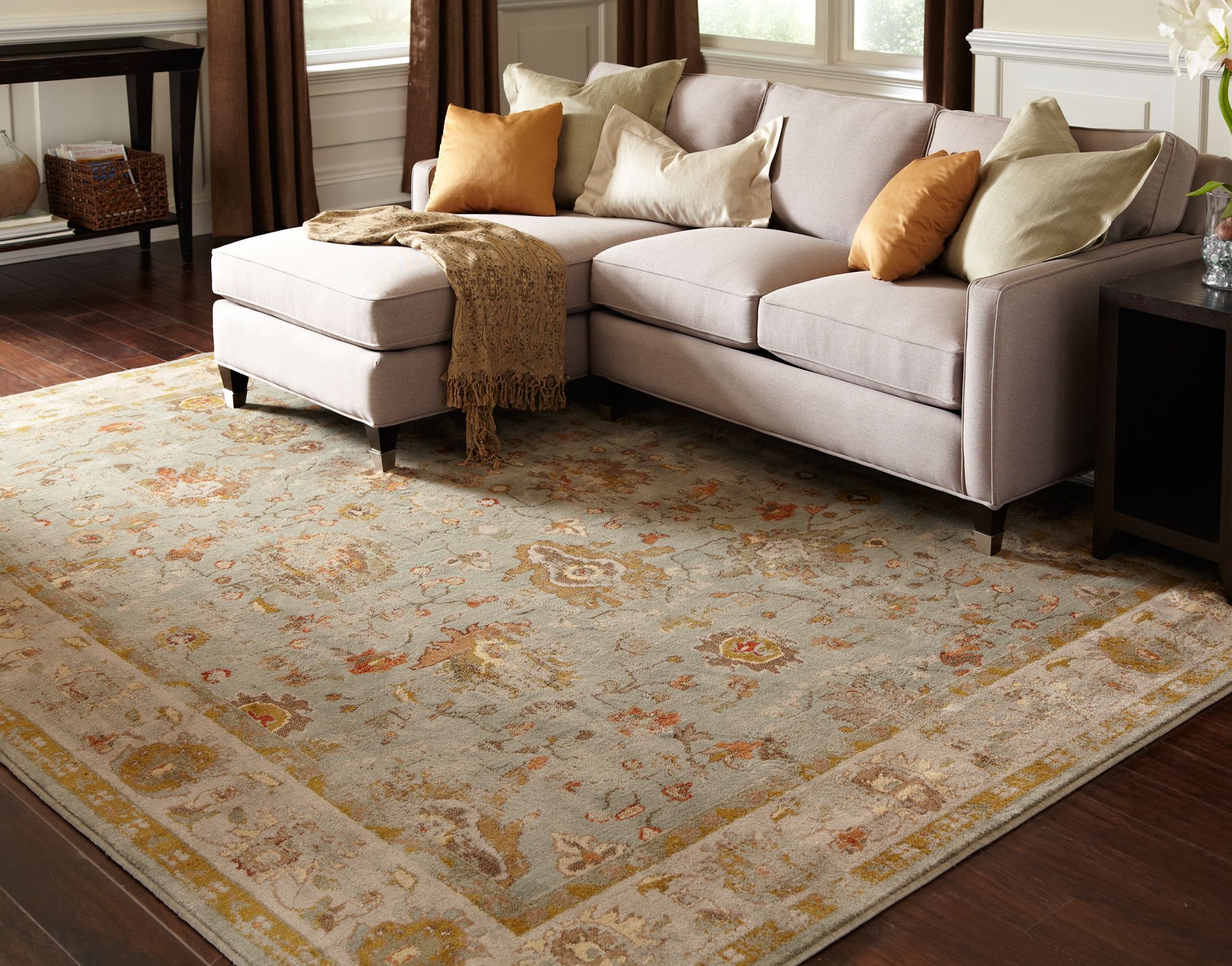 A living room with a sectional couch and a rug