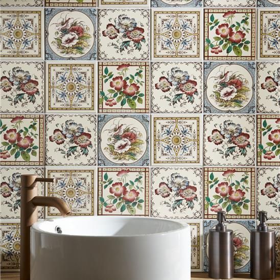 A bathroom with a floral tile wall and a sink