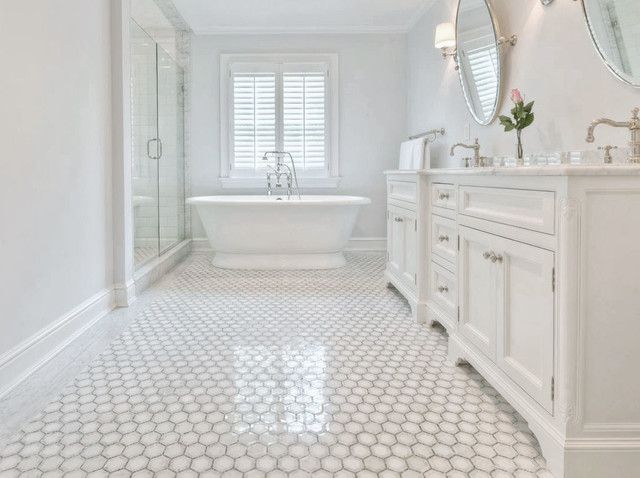 A bathroom with a tub , sinks , mirrors and shutters.