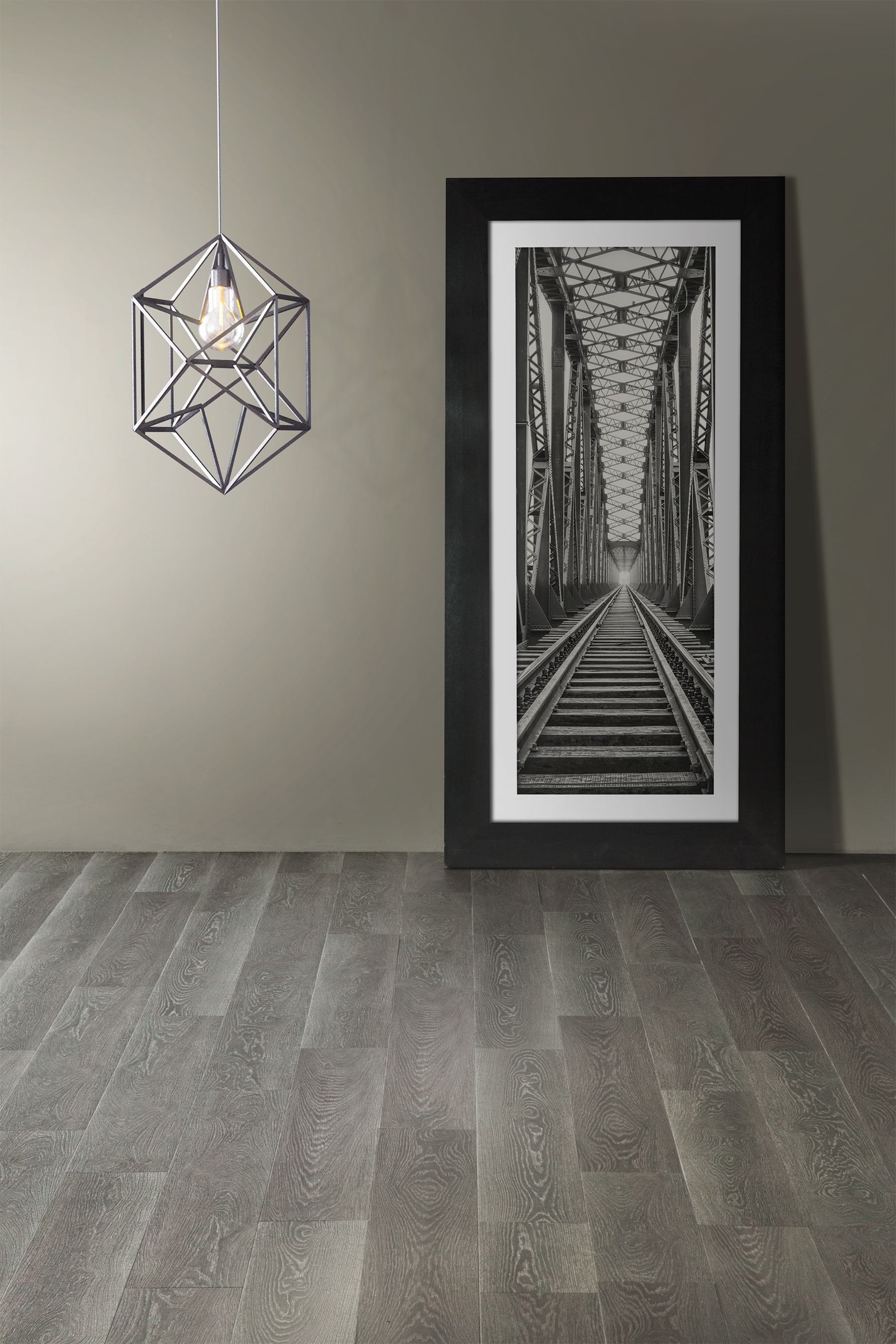 A black and white photo of train tracks is hanging on a wall.