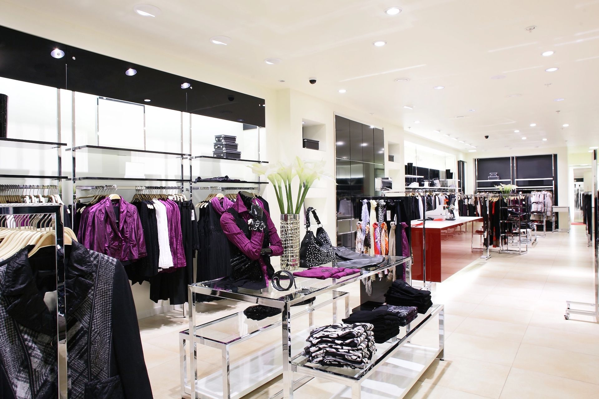 Clothing rack with various garments in front of a blurred office setting.