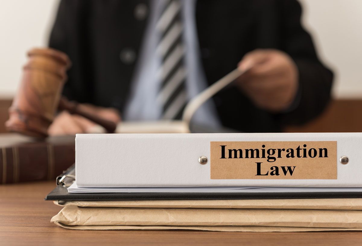 Close-up of a folder with the immigration law tag, from an immigration attorney in the background.