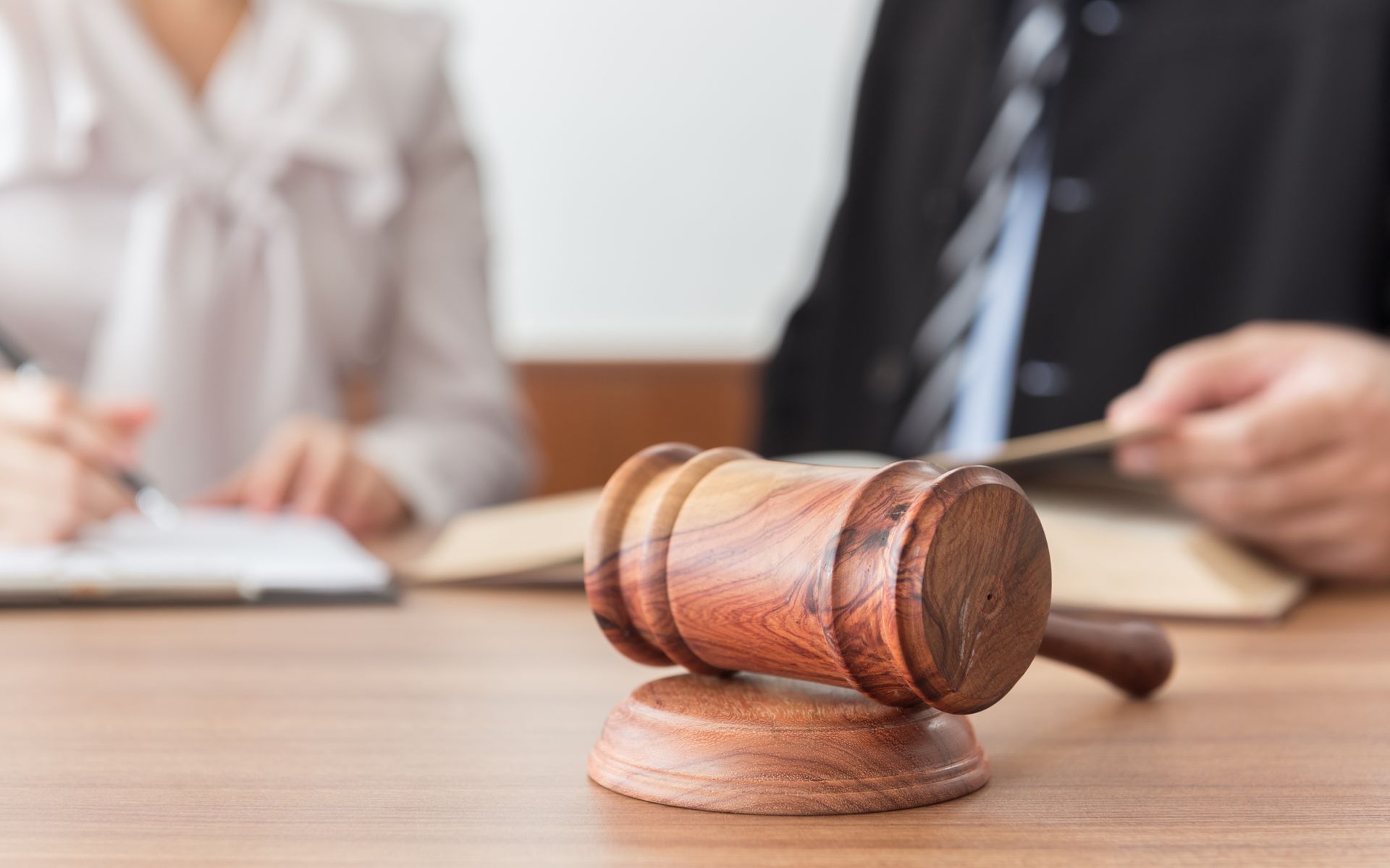 Immigration Lawyer in Norcross, GA at Wang and Associates discussing legal documents with clients in a courtroom setting.
