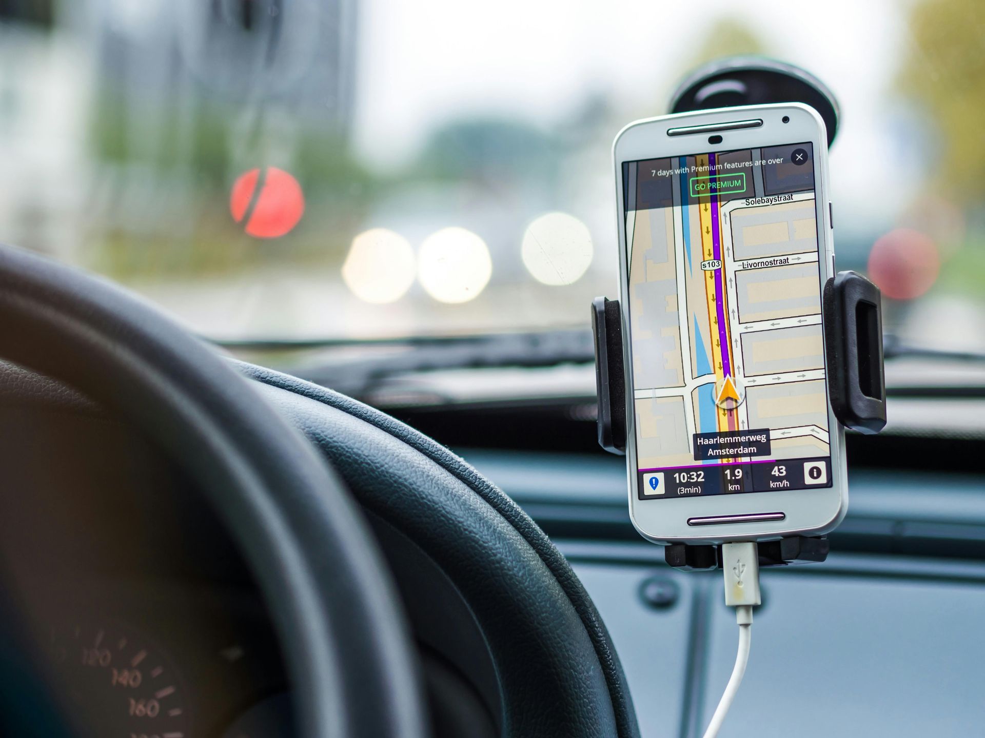 Picture of a cell phone mounted to a windshield with a map application providing directions to the destination