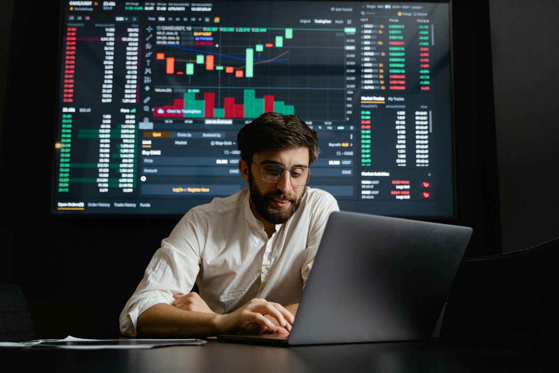 Picture of an analyst  compiling data from multiple information sources and projecting his laptop 