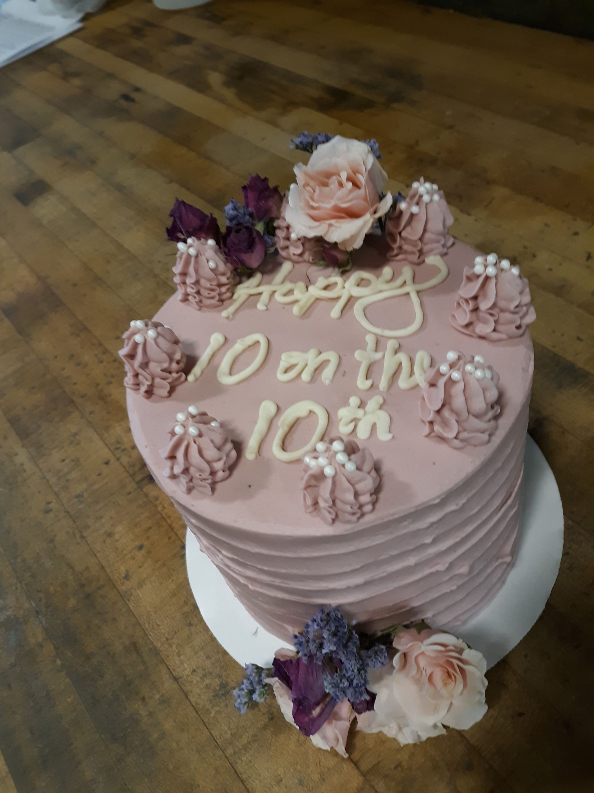 A pink cake that says happy 10 on the 10th