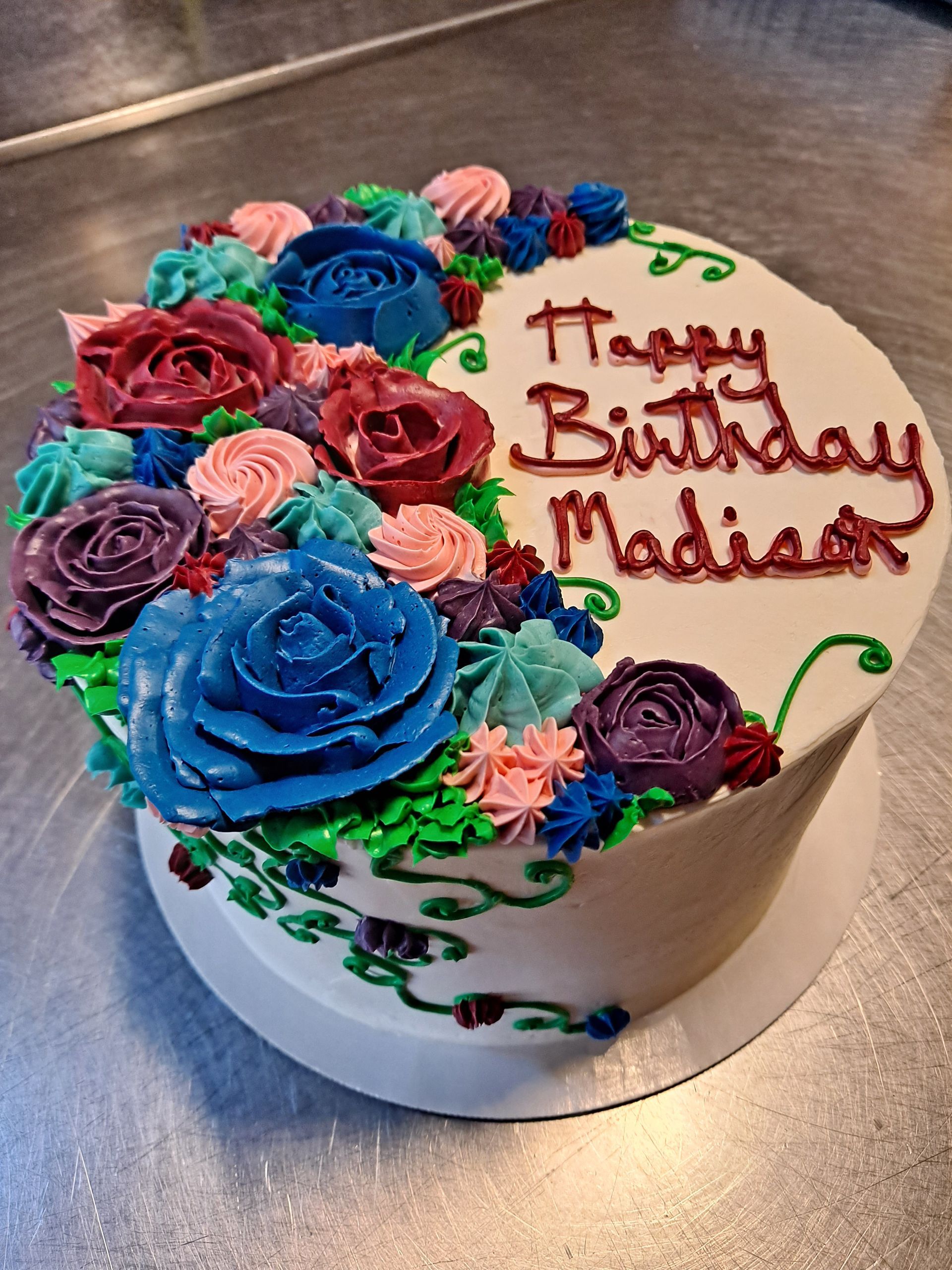 A birthday cake with flowers and the name madison on it