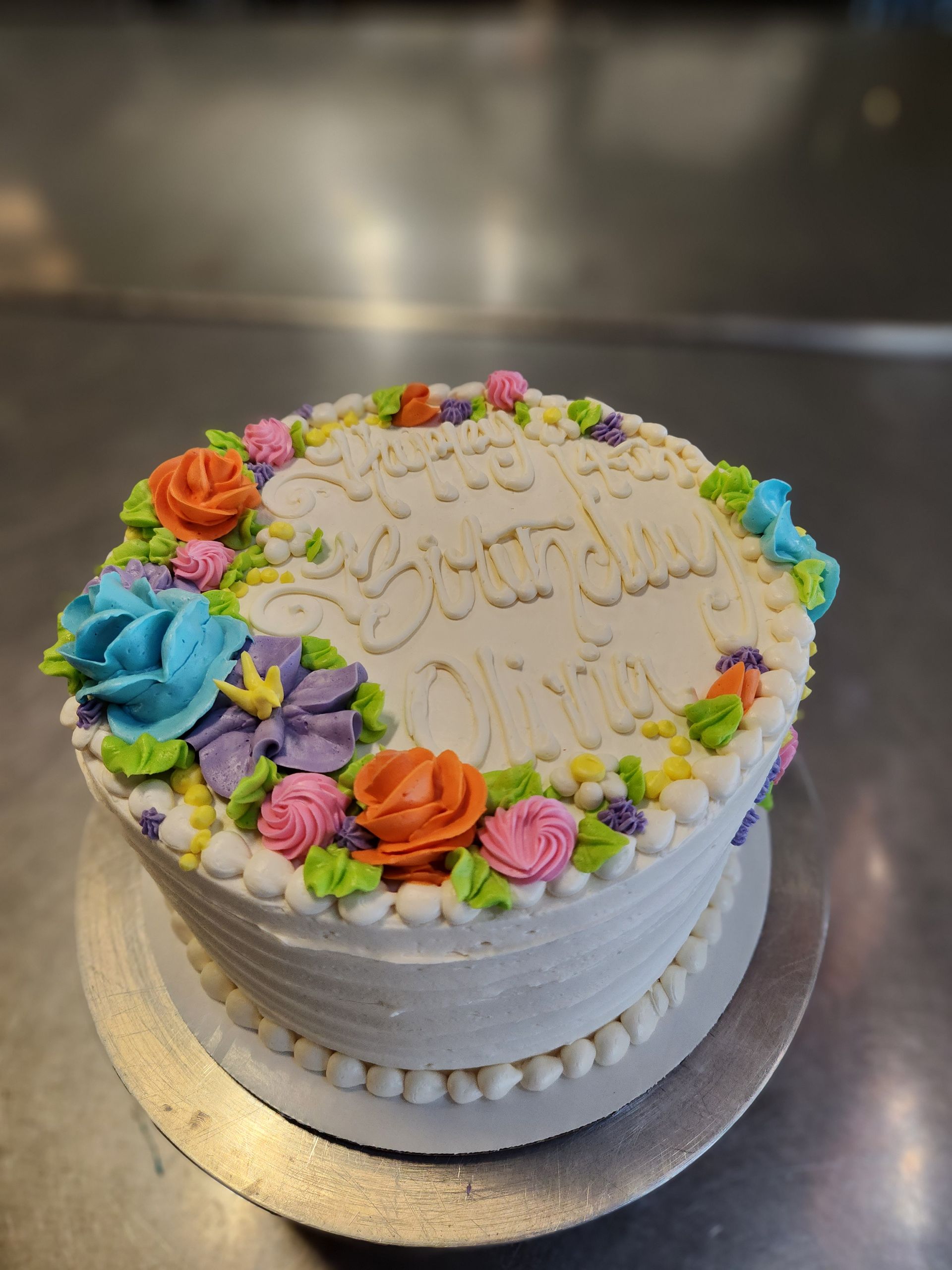 A white cake with colorful frosting and writing on it
