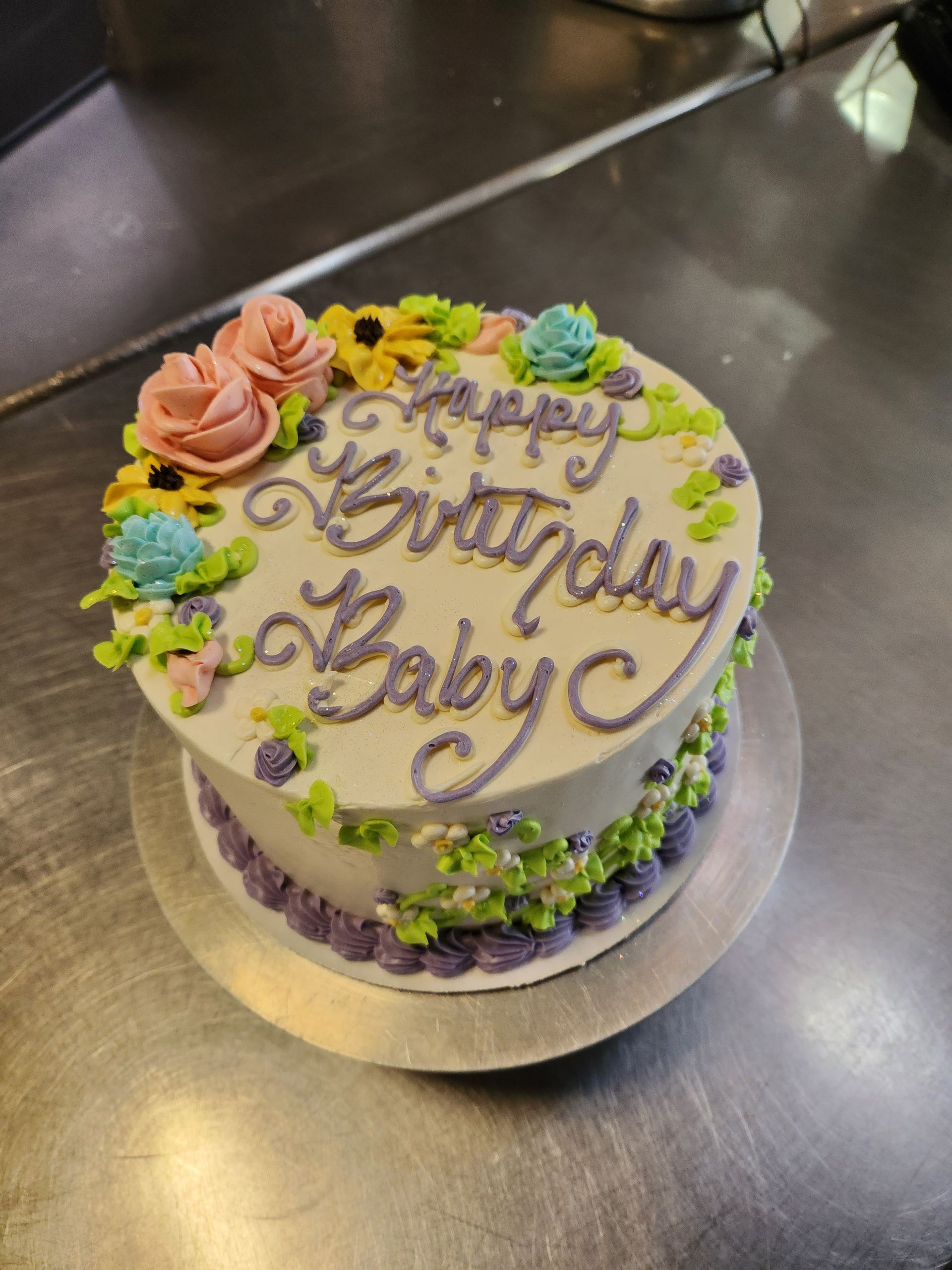 A birthday cake with flowers and the words happy birthday baby on it