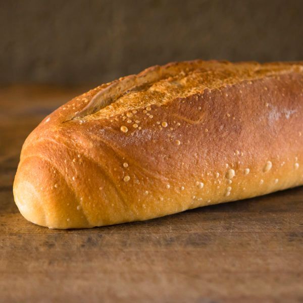 A loaf of bread is sitting on a wooden table.