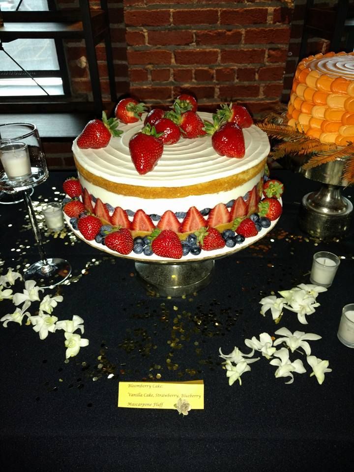 A cake with strawberries and blueberries on top of it