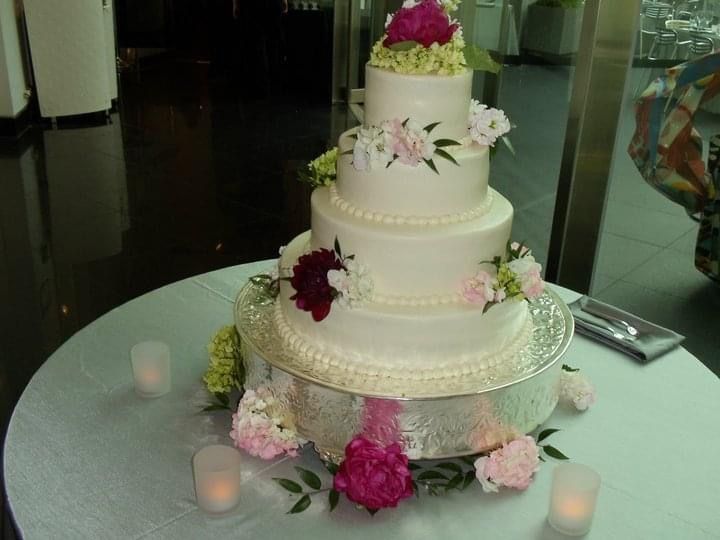 A wedding cake on a table with candles and flowers