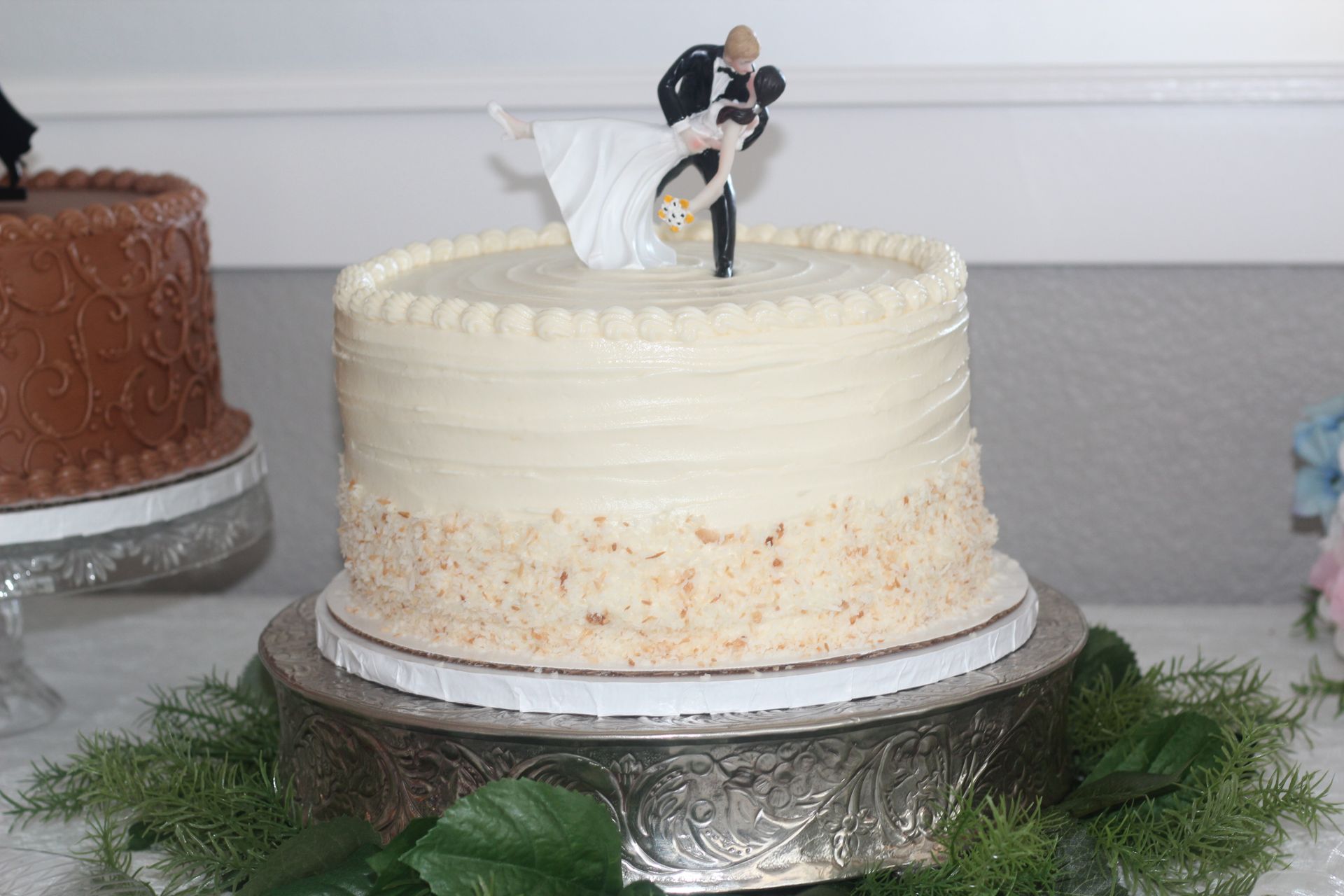 A wedding cake with a bride and groom figurine on top