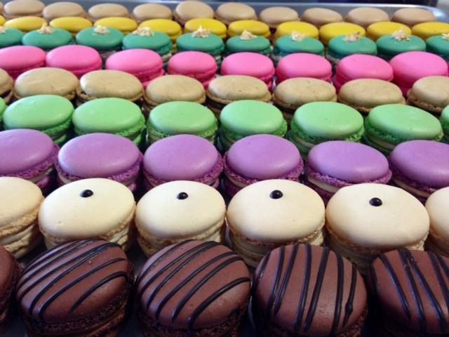 A bunch of different colored macarons on a tray