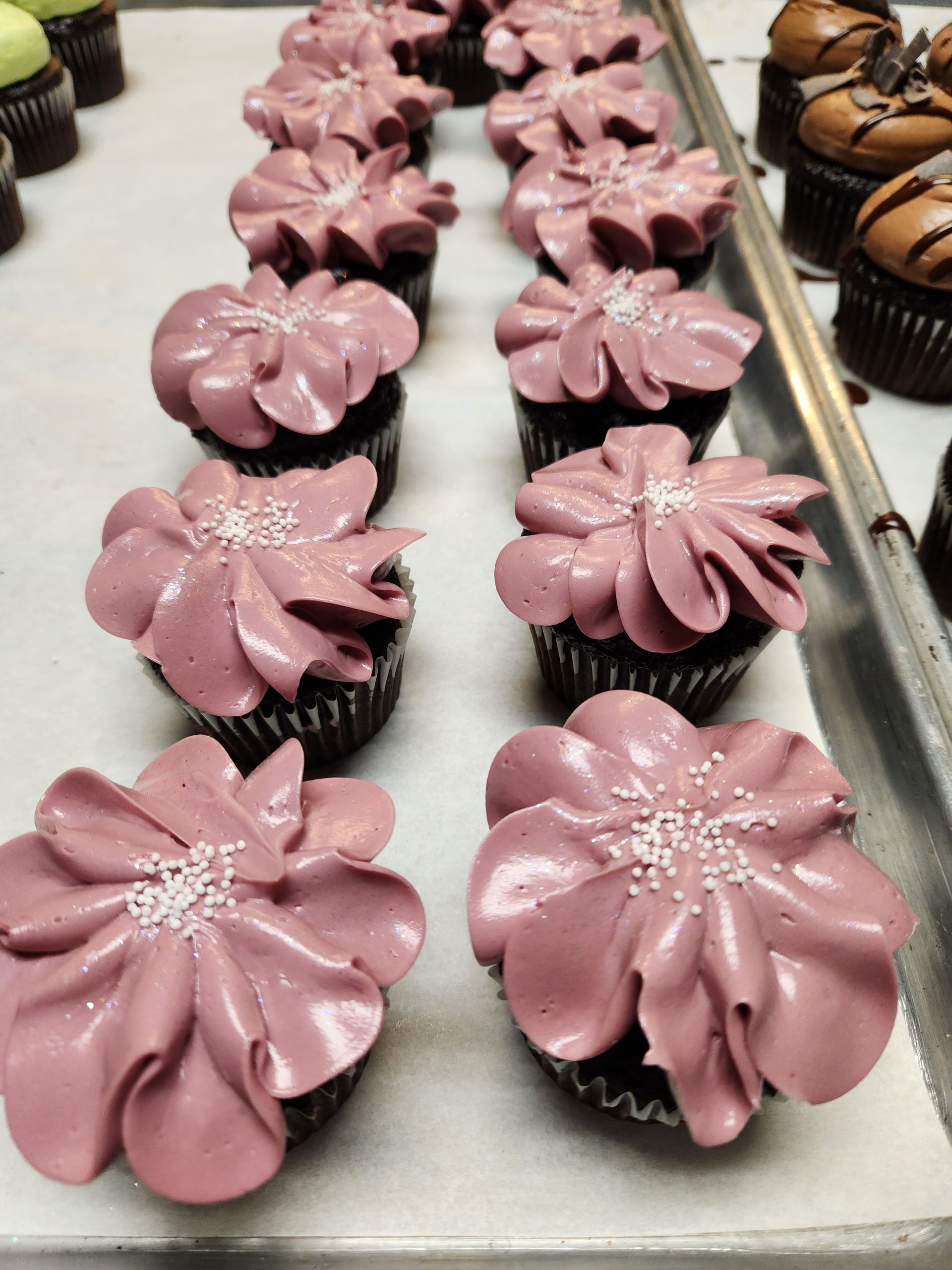 A row of cupcakes with pink frosting and sprinkles