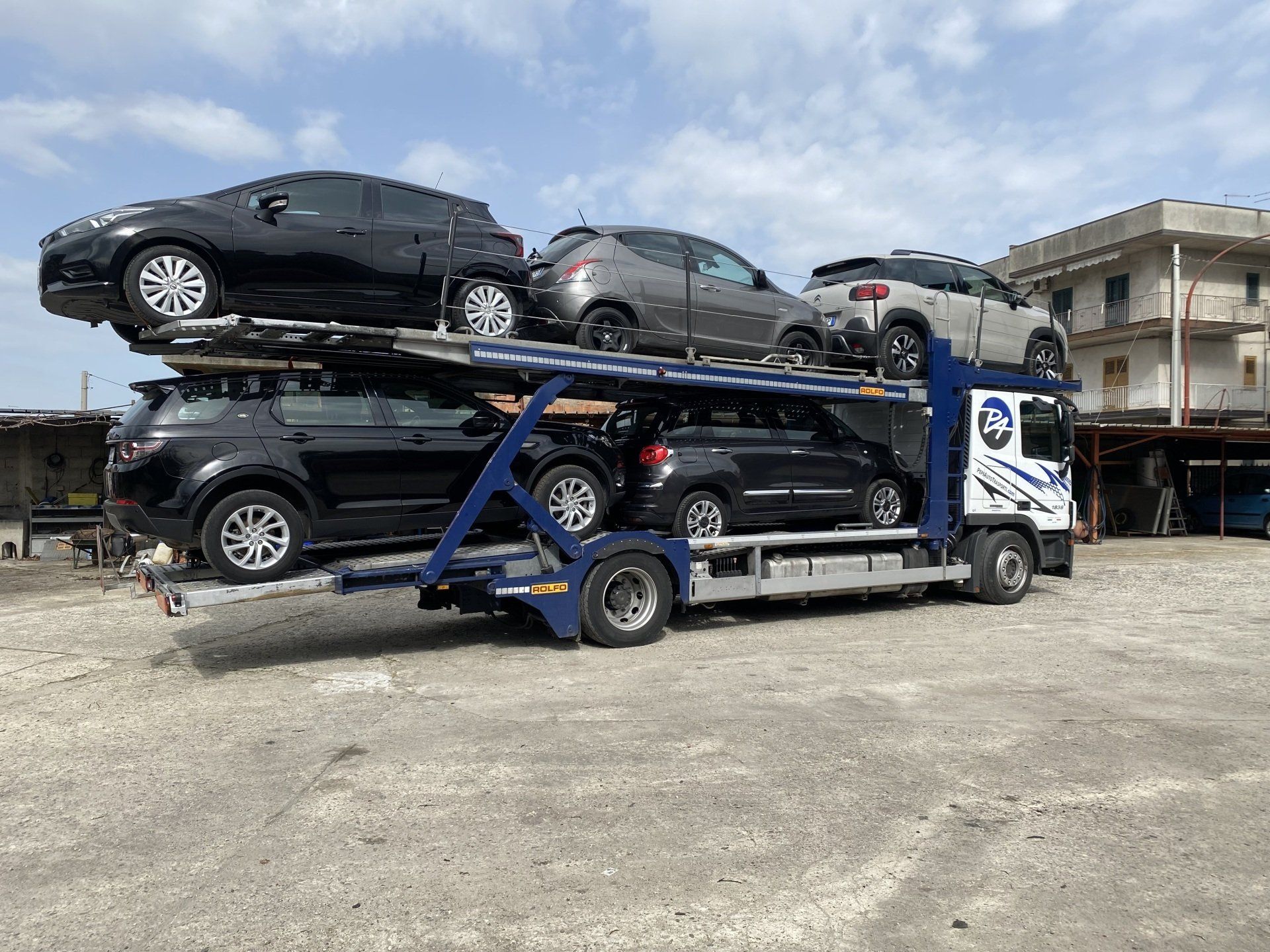 Un camion trasporta un mucchio di auto su un rimorchio.