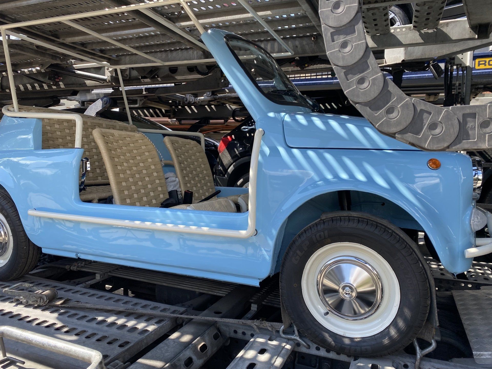 Un'auto blu è parcheggiata sopra un rimorchio.