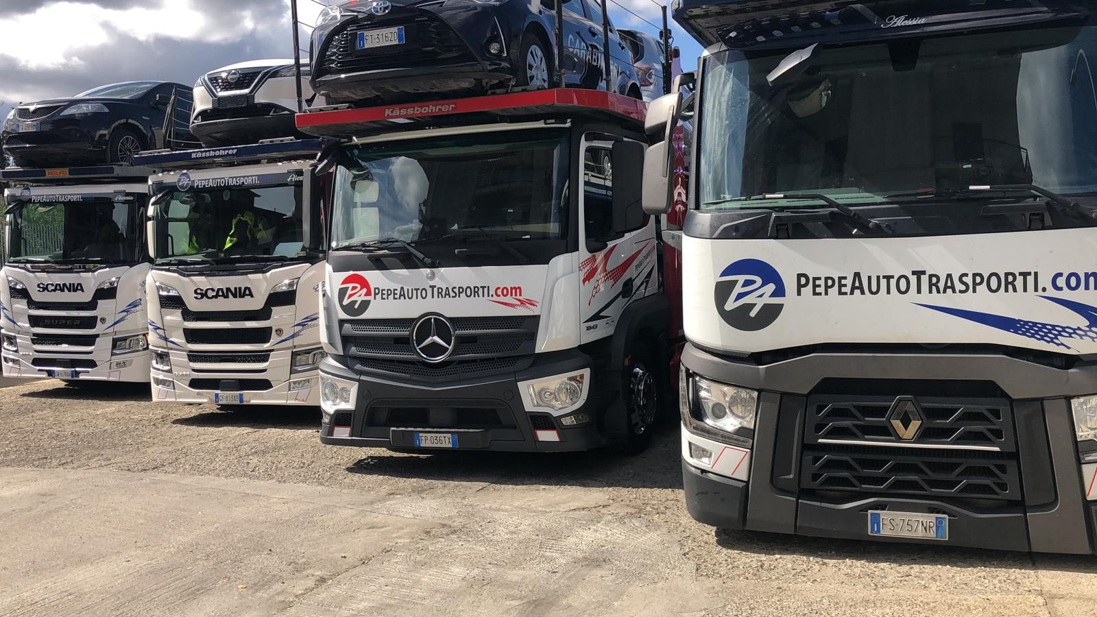 Una fila di camion parcheggiati uno accanto all'altro in un parcheggio.