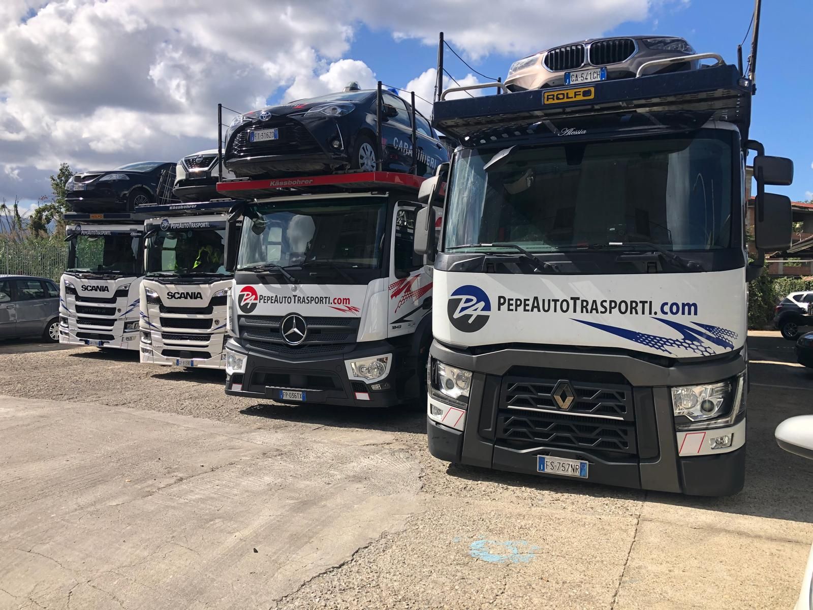 Una fila di camion parcheggiati uno accanto all'altro in un parcheggio.