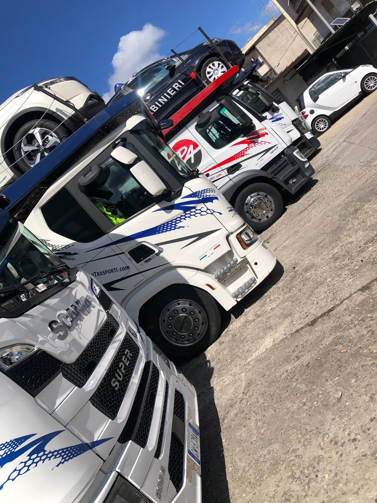 Una fila di camion sono parcheggiati uno accanto all'altro in un parcheggio.