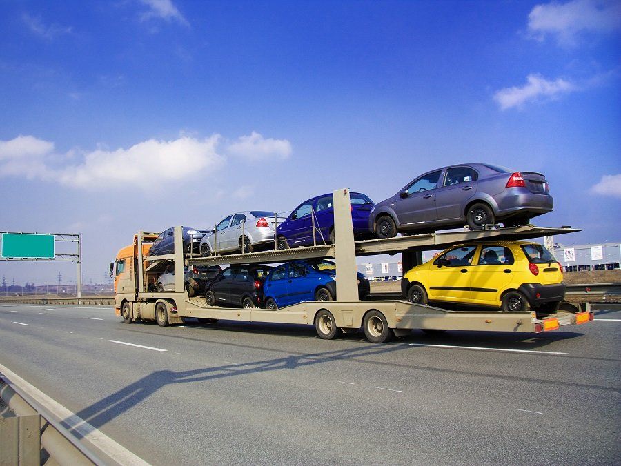 Un camion trasporta delle auto su un rimorchio su un'autostrada.