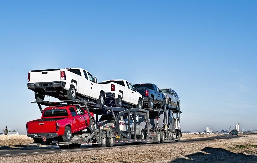 Un camion trasporta un mucchio di auto su un rimorchio.