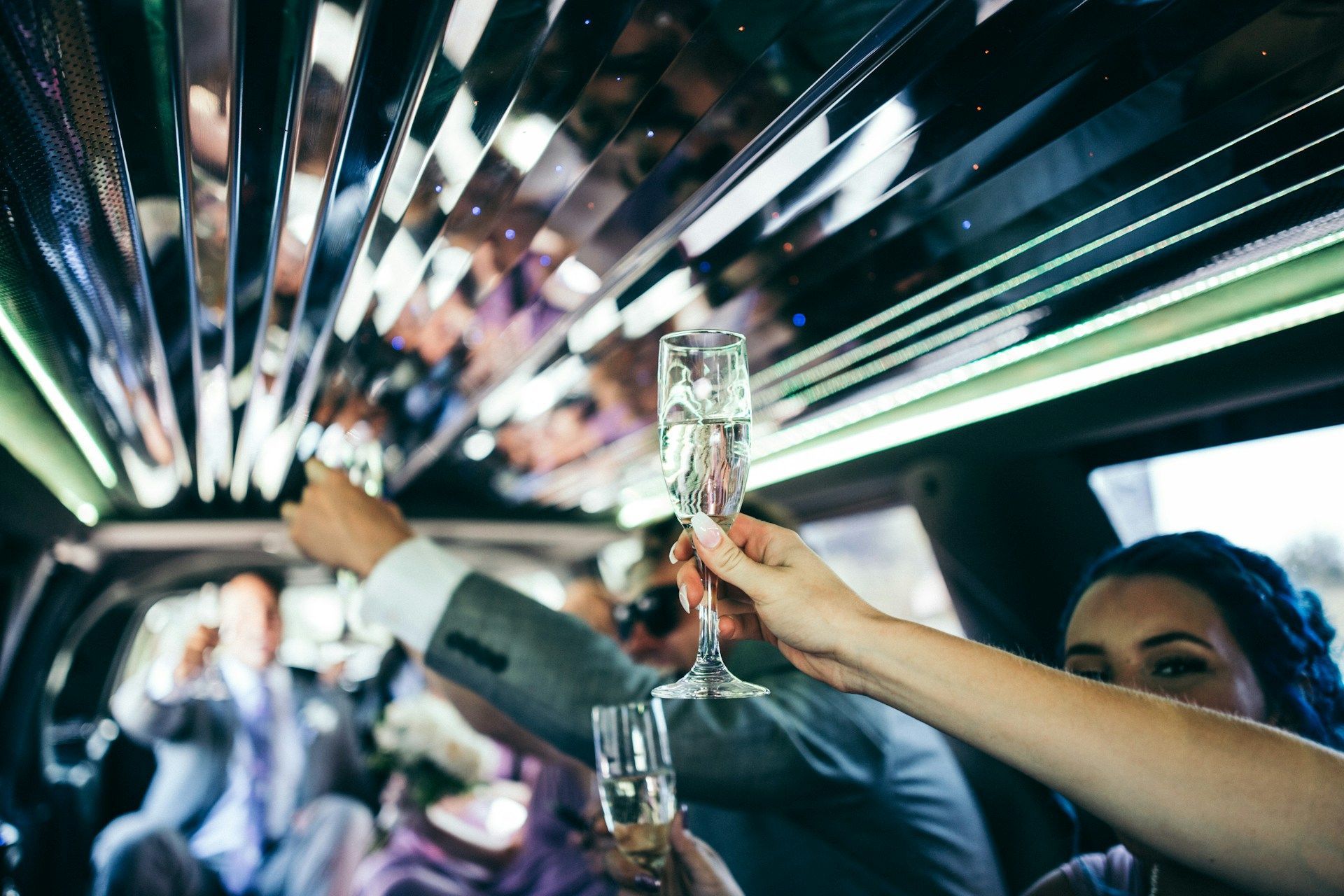 People in a limo toasting with champagne flutes, celebratory mood.