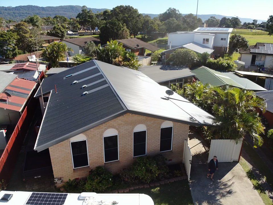 Aerial View of a Brick House With a Dark Gray Roof — Elevated Roofing Systems Pty Ltd In Barrack Heights, NSW