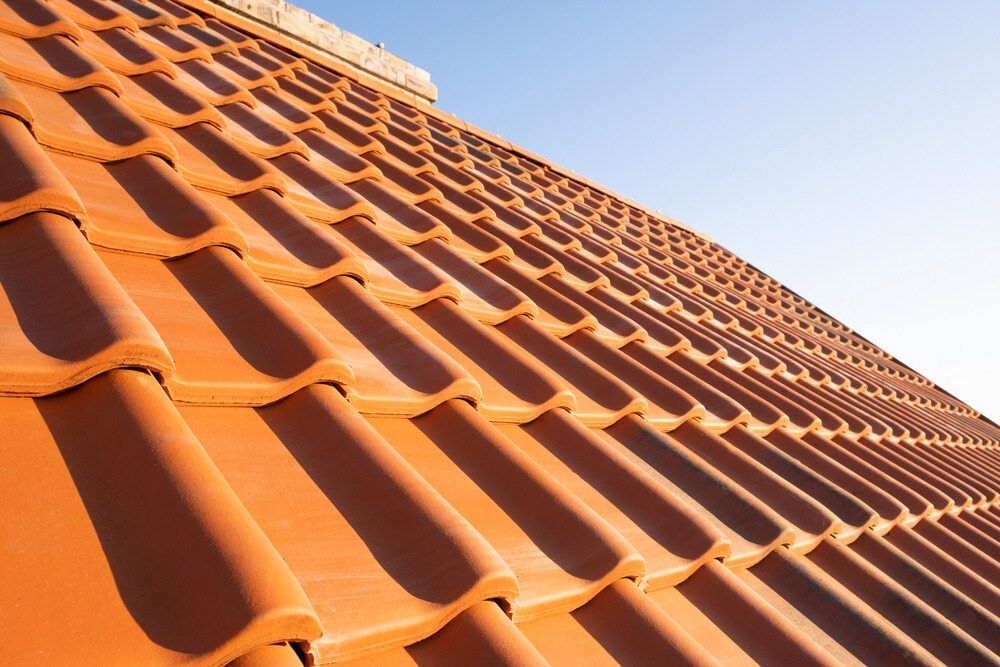 A Close Up Of A Tiled Roof With A Blue Sky In The Background — Elevated Roofing Systems Pty Ltd In Nowra, NSW