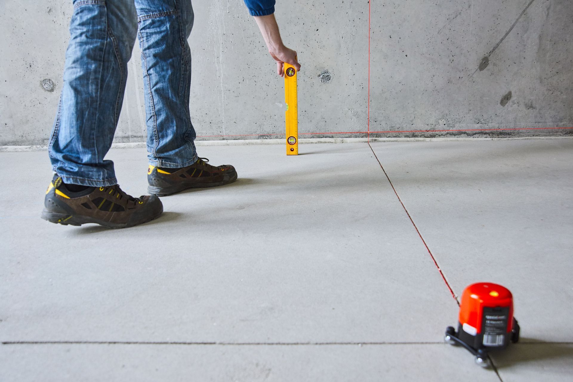 man with laser level check floor and walls