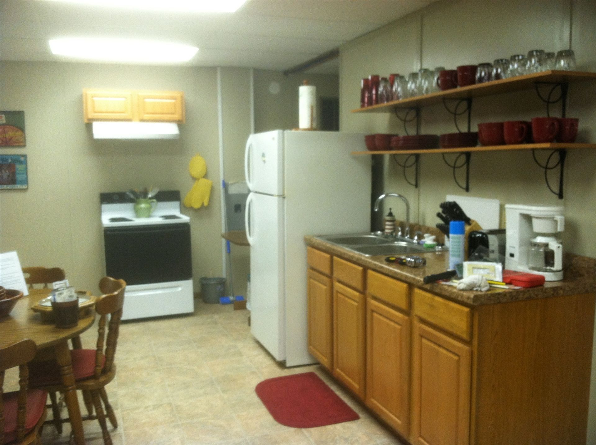 Small kitchen with white appliances, wooden cabinets, and a dining table.