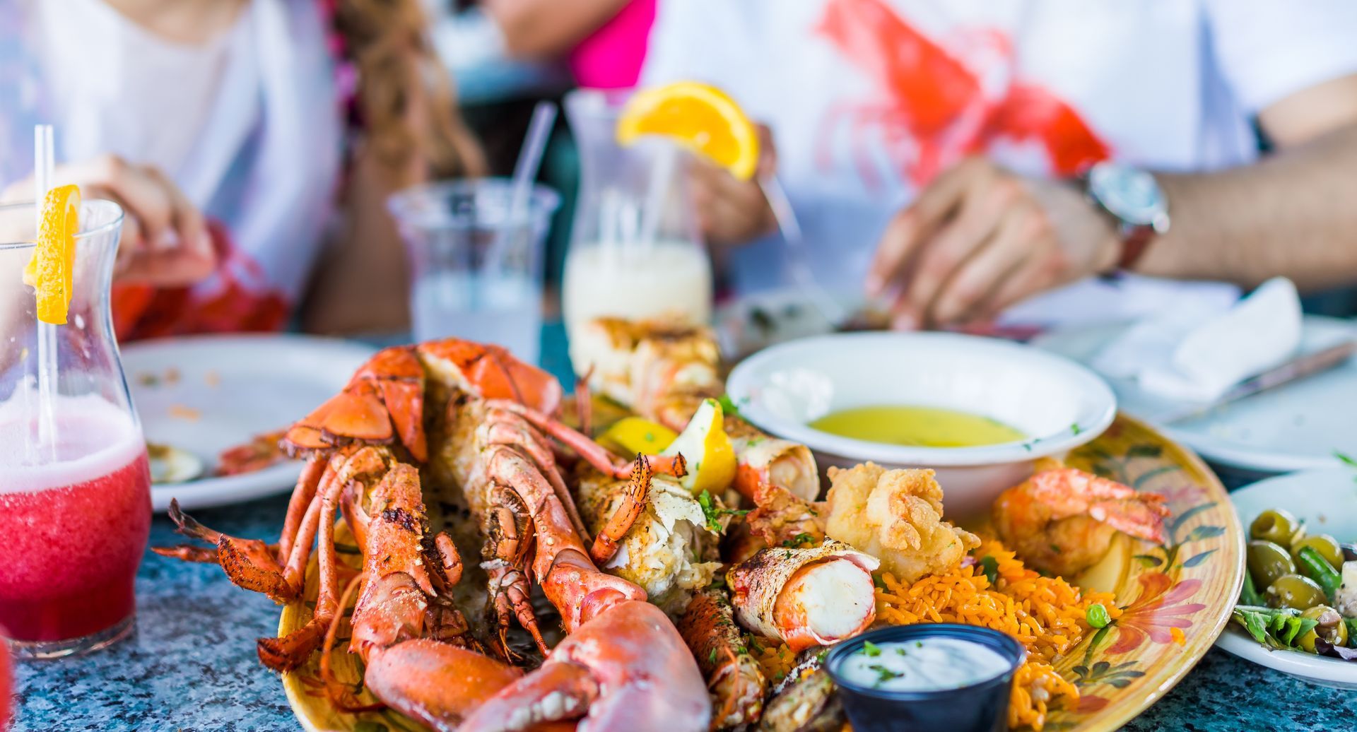 Seafood feast with crabs, shrimp, rice, and cocktails on a restaurant table