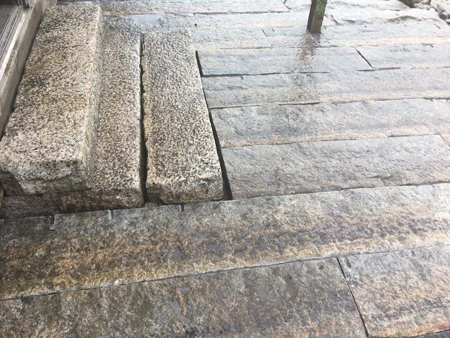 Stone steps and paving stones, wet, outdoors.