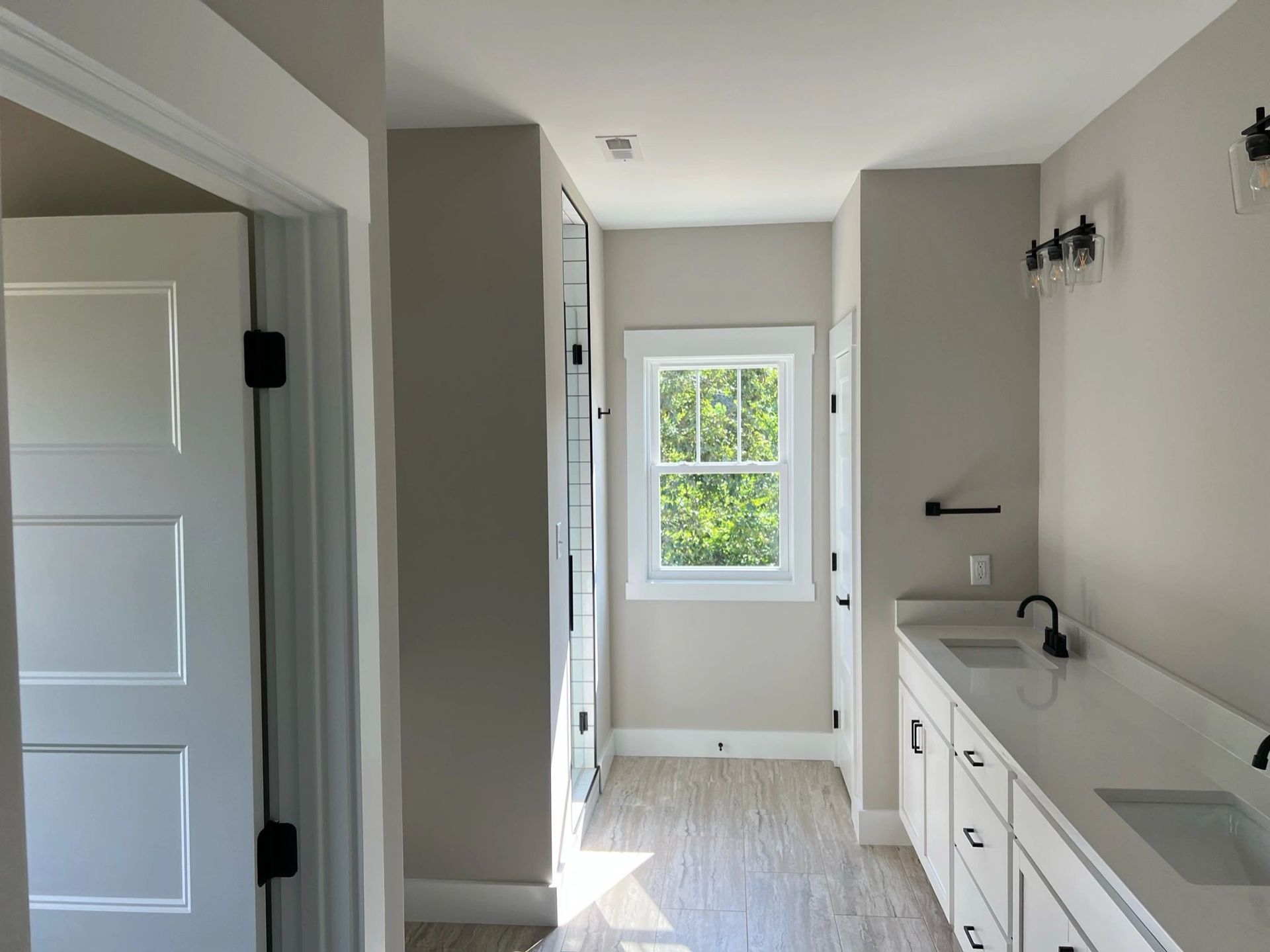 A bathroom with a sink , cabinets and a window