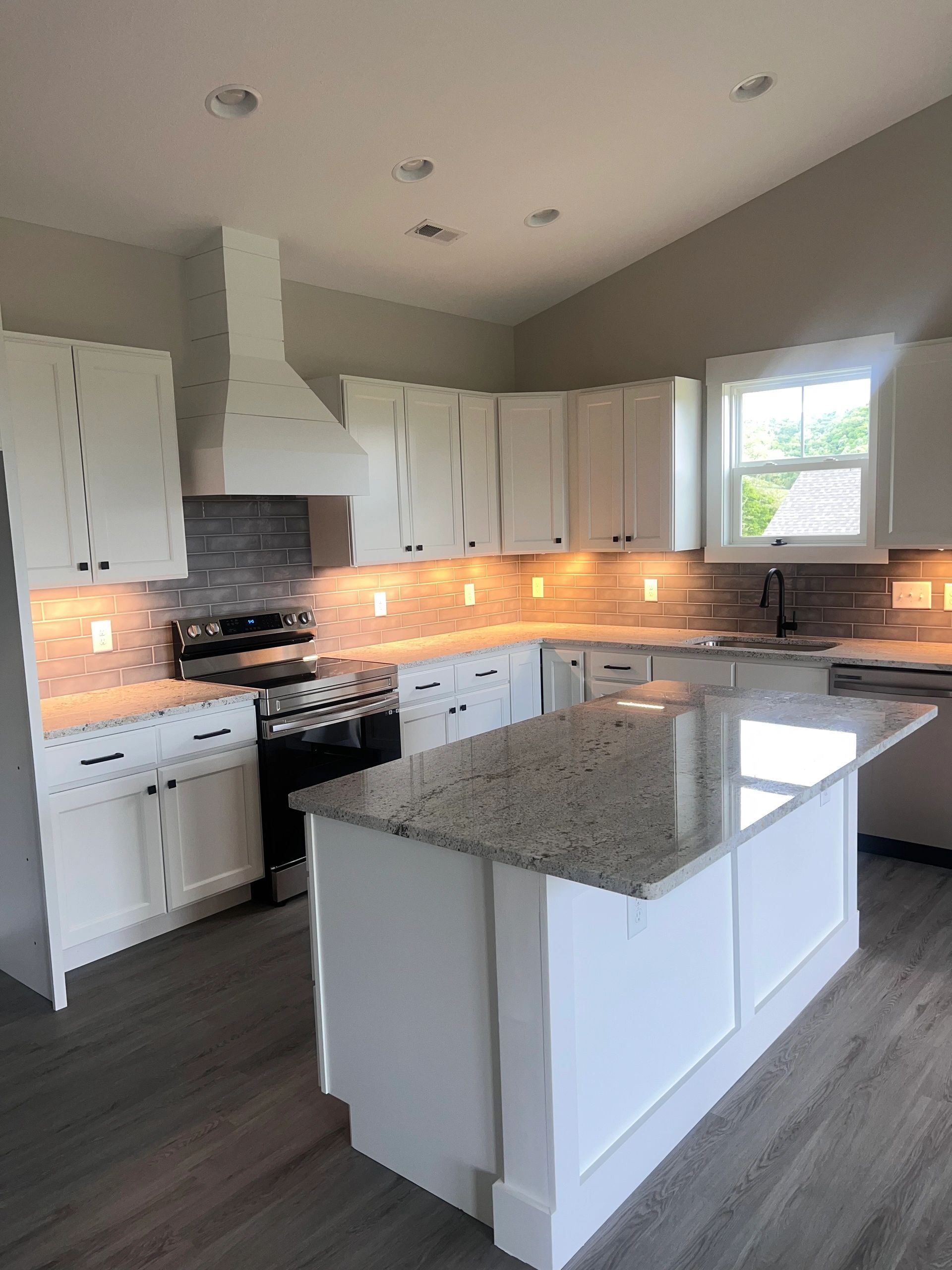 A kitchen with white cabinets and granite counter tops