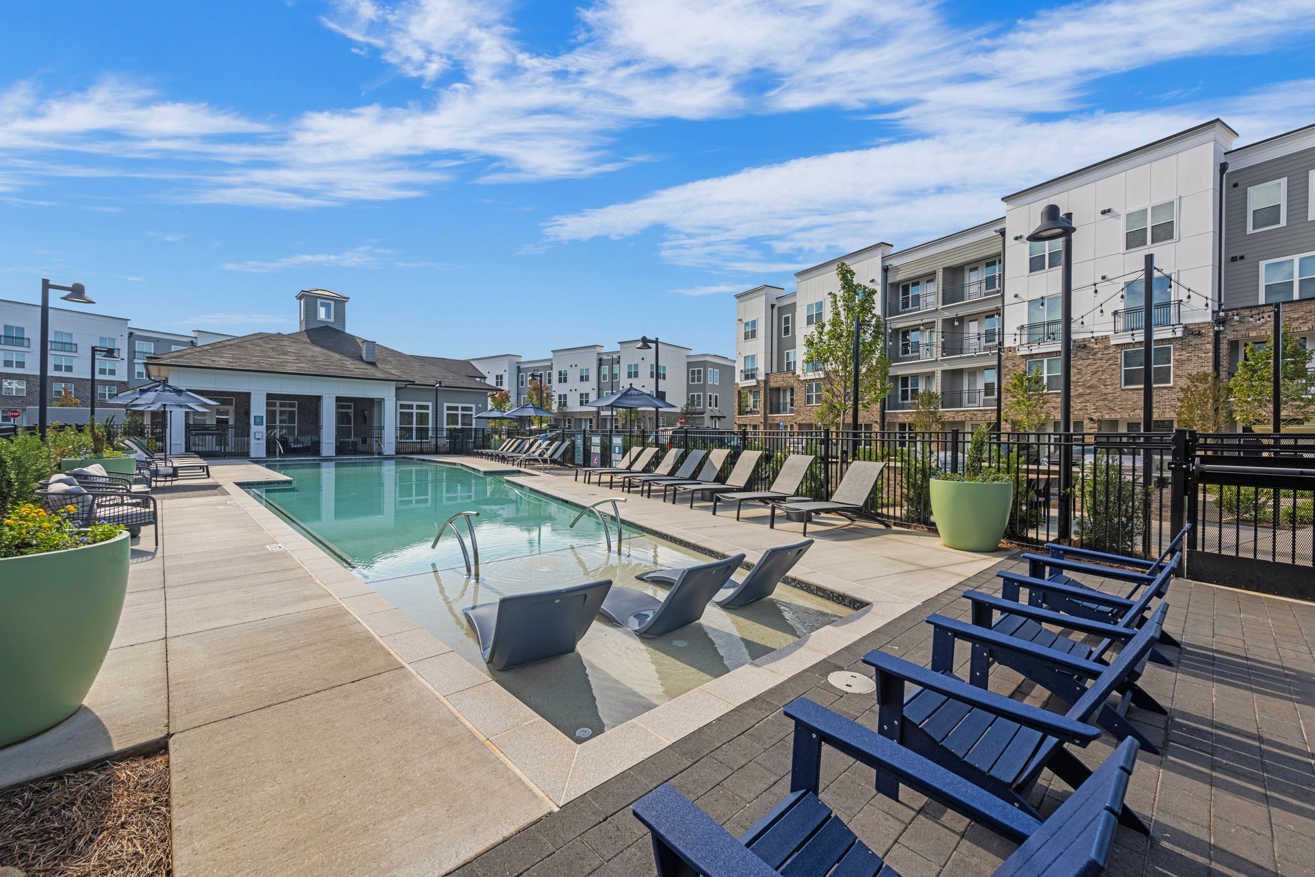 A row of chairs are sitting next to a large swimming pool at SpringSide in Powder Springs, GA.