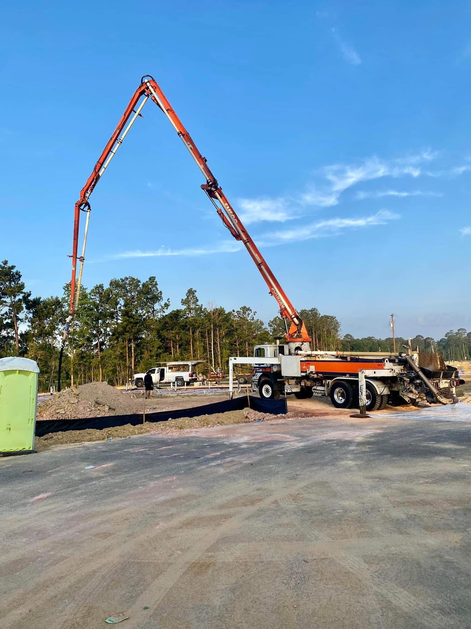 A man in a plaid shirt is working on a concrete mixer truck
