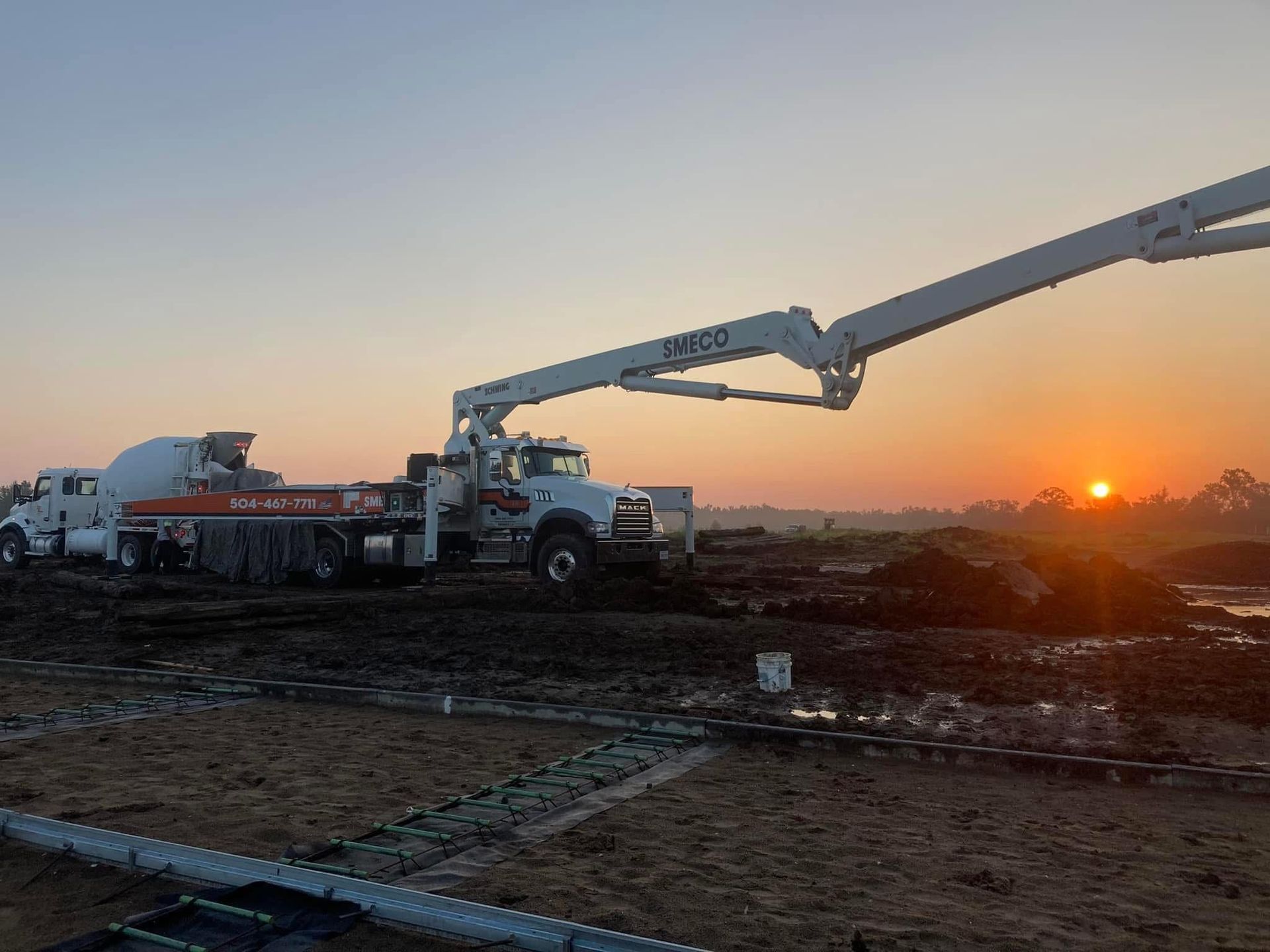 A concrete pump is being used to pour concrete into a building under construction.