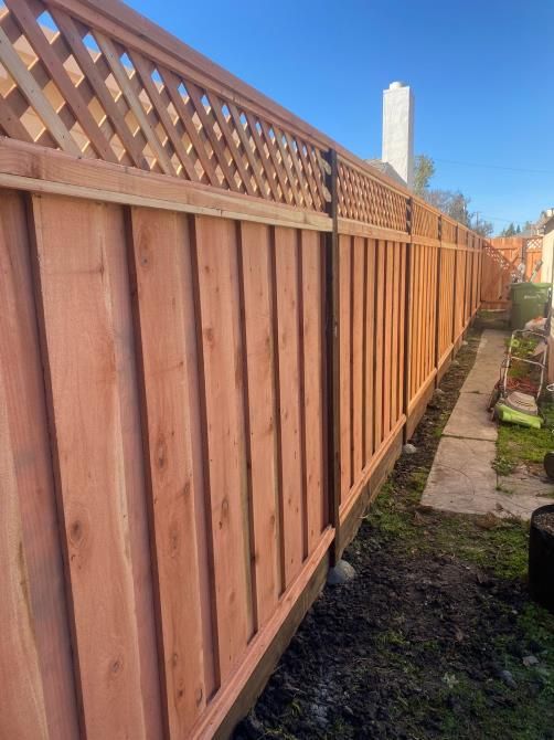 Skilled worker repairing the wooden fence around a house, using tools and materials to fix and reinforce the structure.