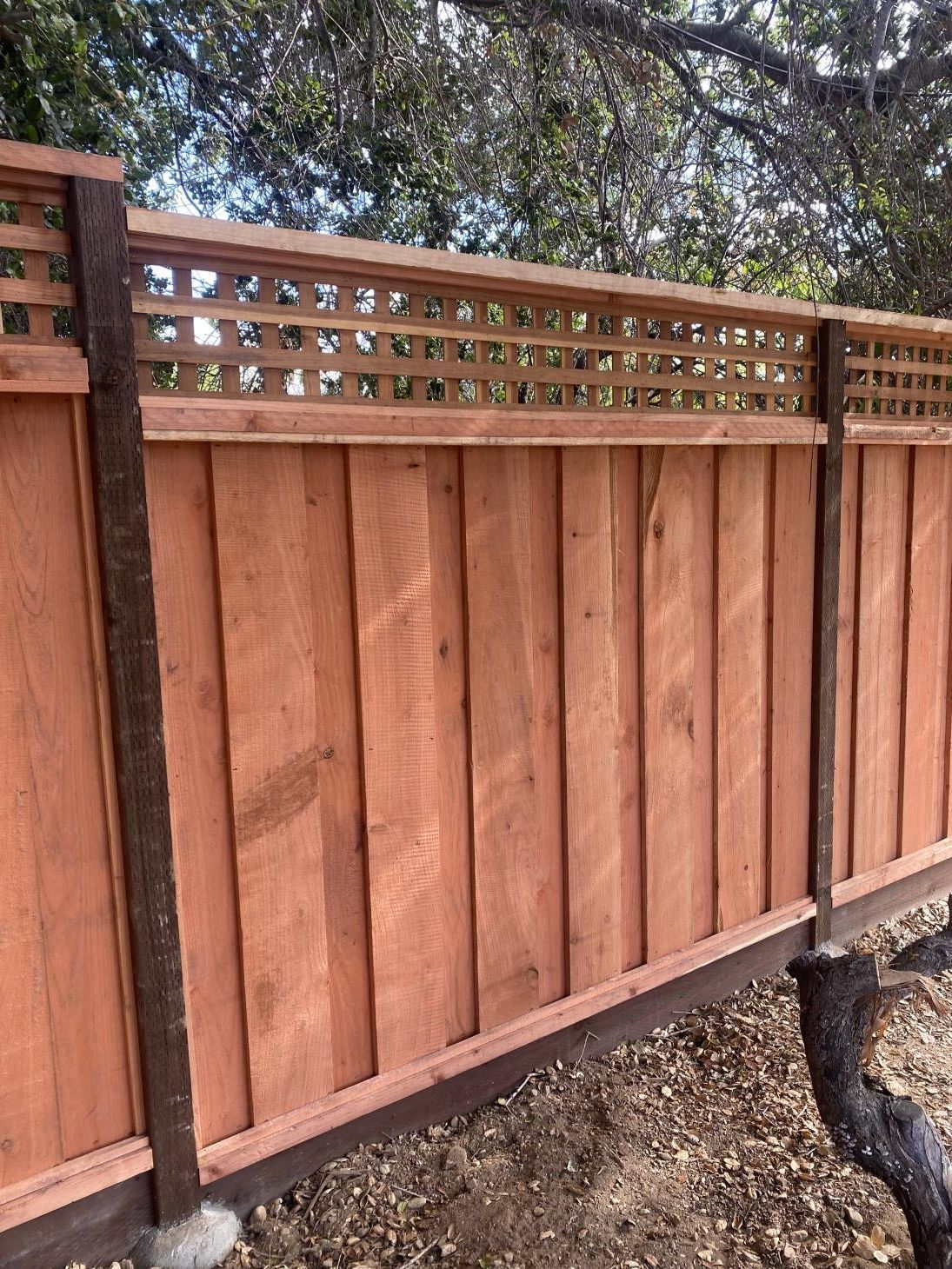 Rustic wooden fence, with weathered planks and visible grain patterns, enclosing a garden area.