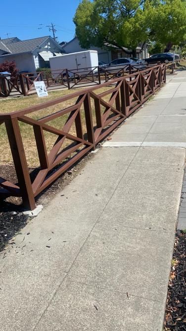 A temporary metal barrier fence securing a construction site with orange safety markings.