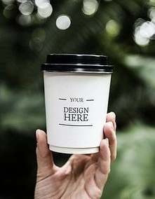 A person is holding a cup of coffee in their hand.