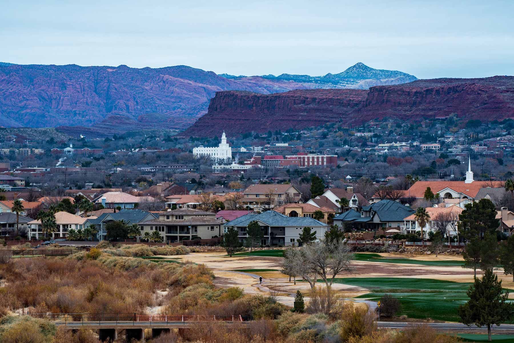 An aerial view of a small town with mountains in the background.