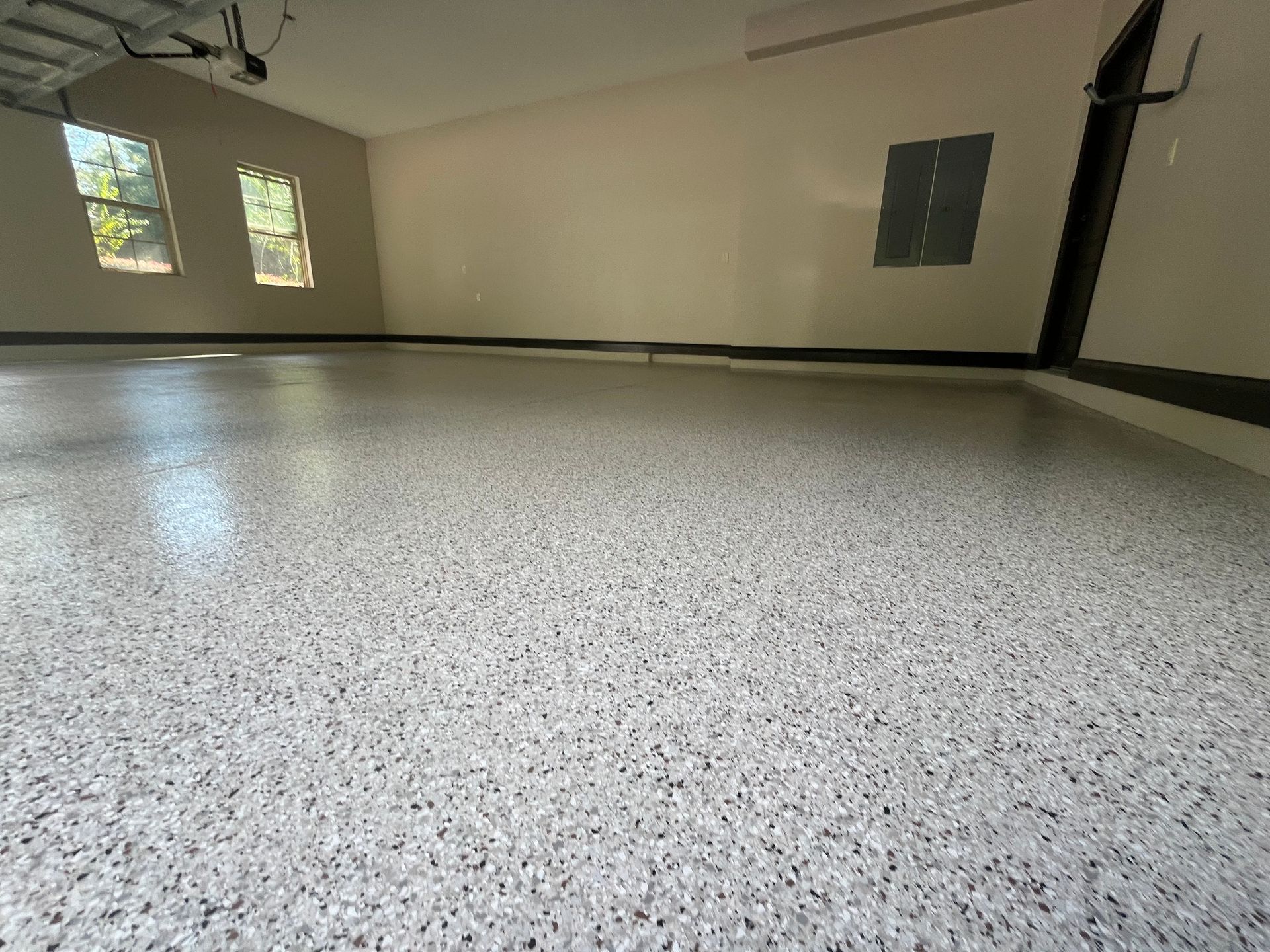 Garage with speckled, light gray epoxy floor; windows in the background.
