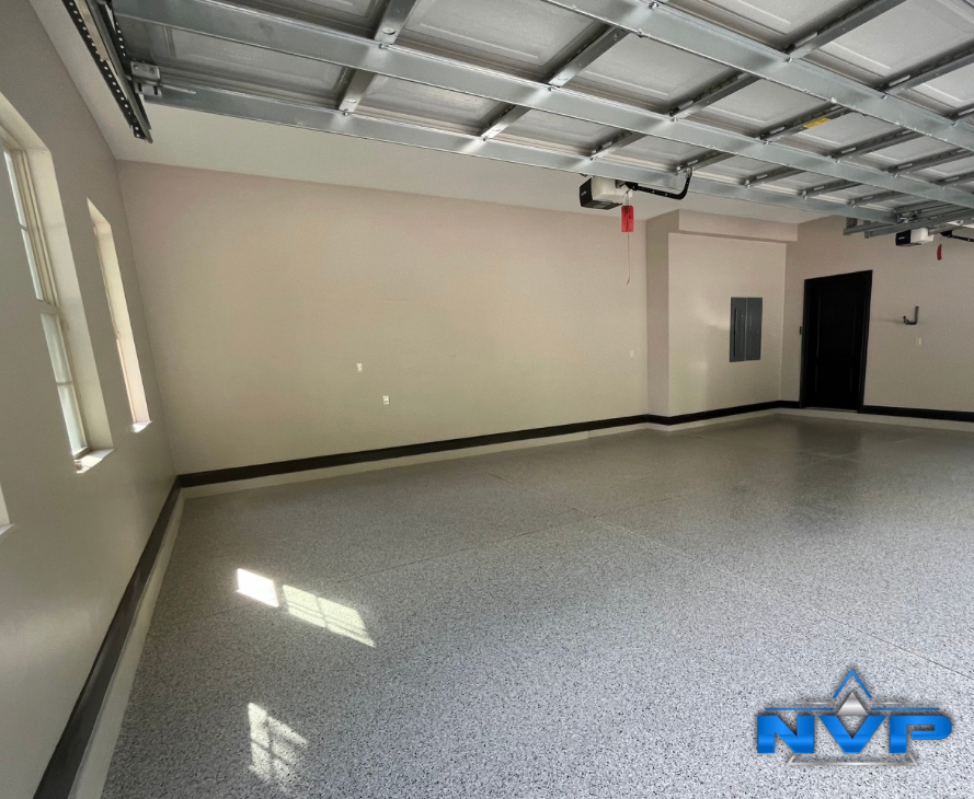 Spacious, newly finished garage with epoxy flooring and beige walls.