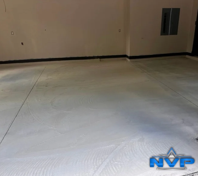 Light gray concrete floor in an empty room, with black trim and a window.