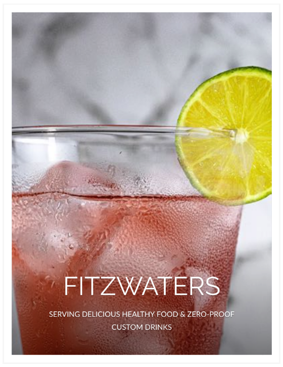 A close up of a glass of fitzwaters with ice and a slice of lime.