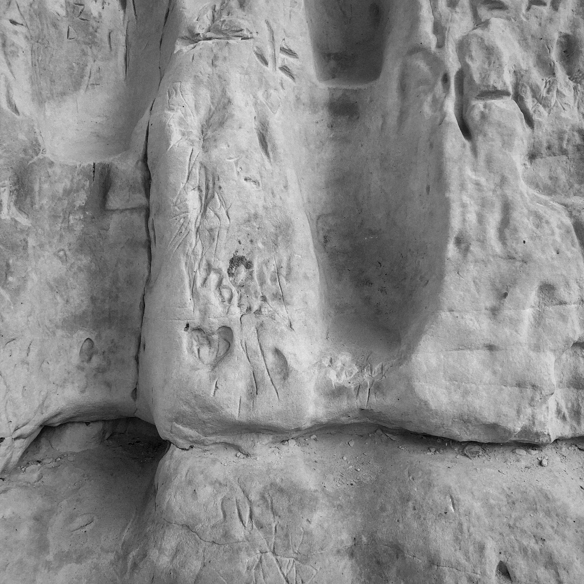 A black and white photo of a rock with a few letters written on it