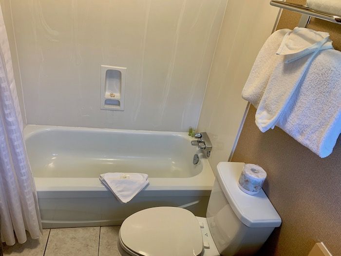 Bathroom with a white bathtub, toilet, and towels.