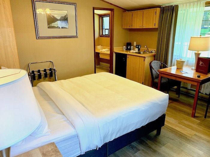 Hotel room with a bed, desk, and small kitchenette.